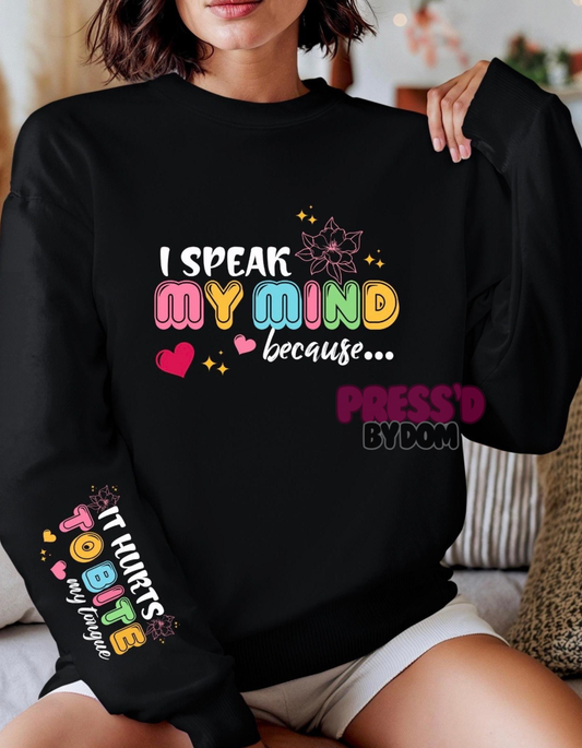 Black crewneck sweatshirt that says “I Speak My Mind Because It Hurts to Bite My Tongue” in colorful retro text with hearts and stars – Press’d by Dom.